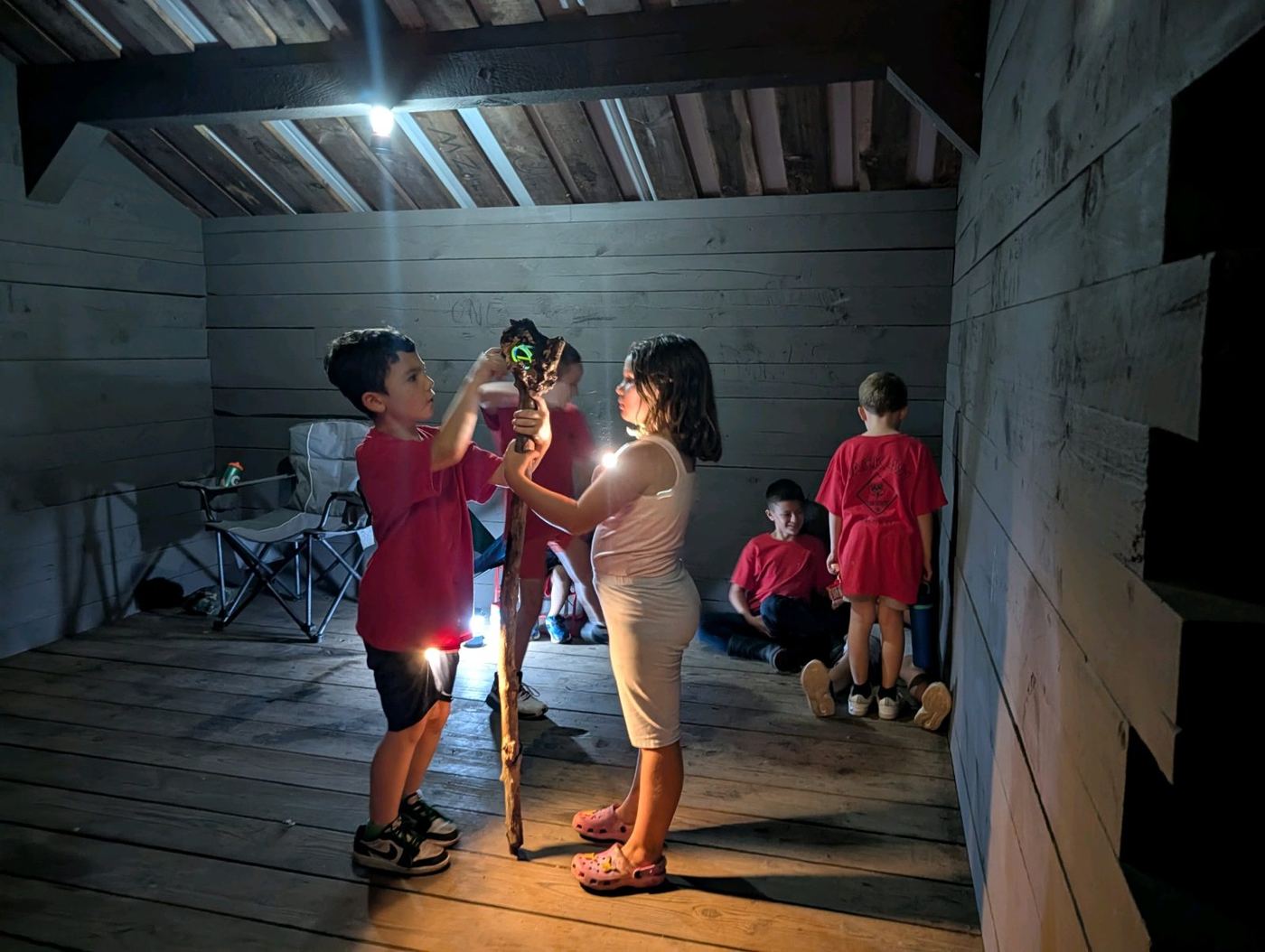 Scouts with flashlights inside a lean-to shelter