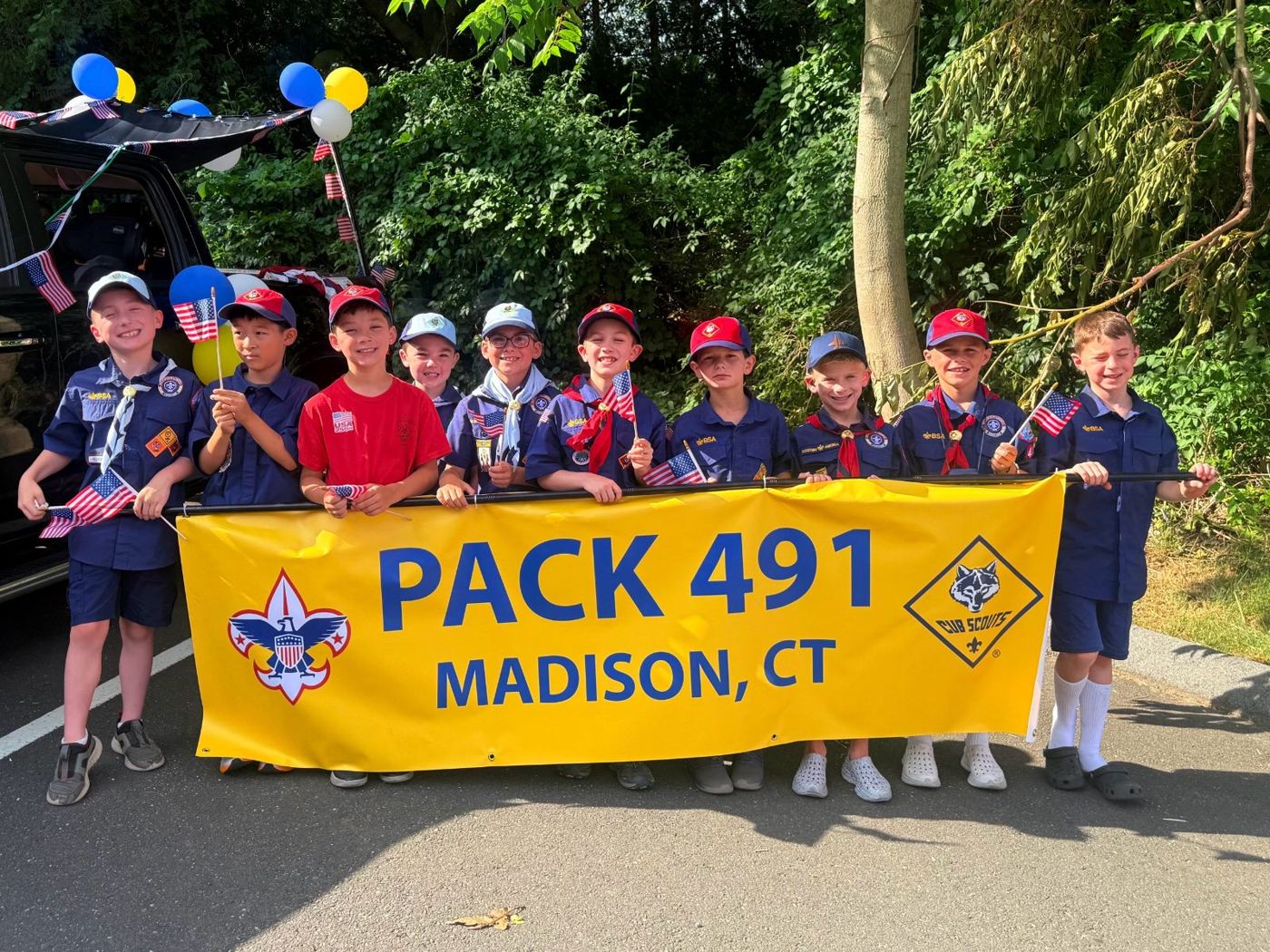 Pack 491 Cub Scouts holding the Pack 491 Madison CT banner at the 4th of July parade