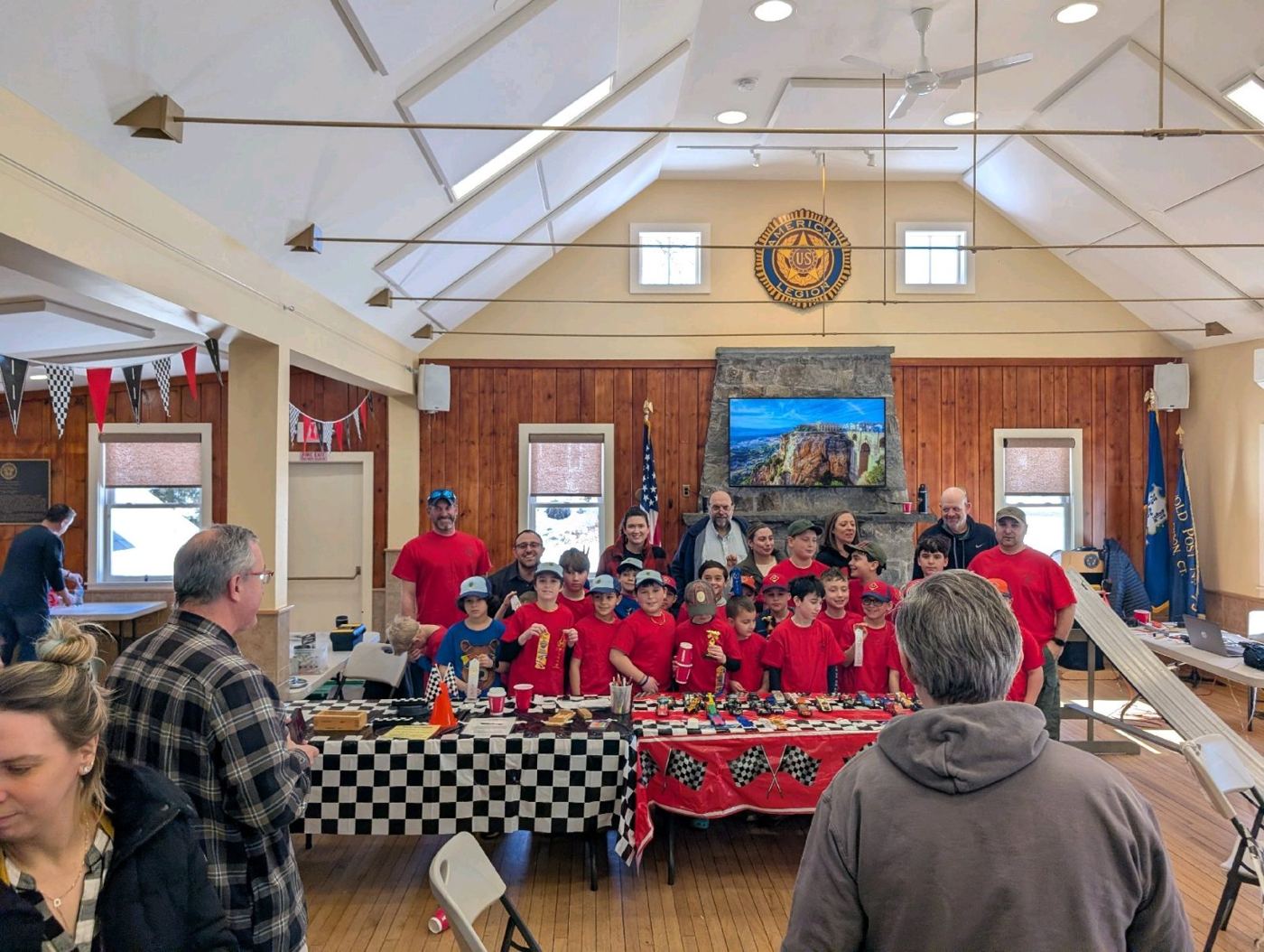 Cub Scouts gathered behind their Pinewood Derby cars on race day