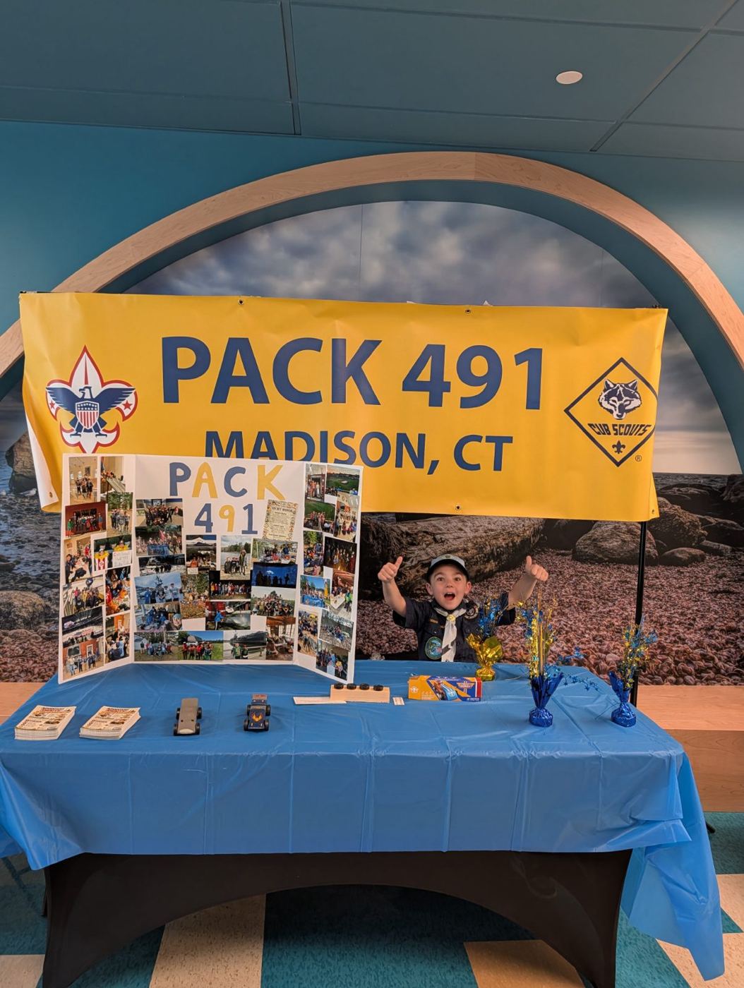 A Cub Scout behind the Pack 491 table at a school recruiting night