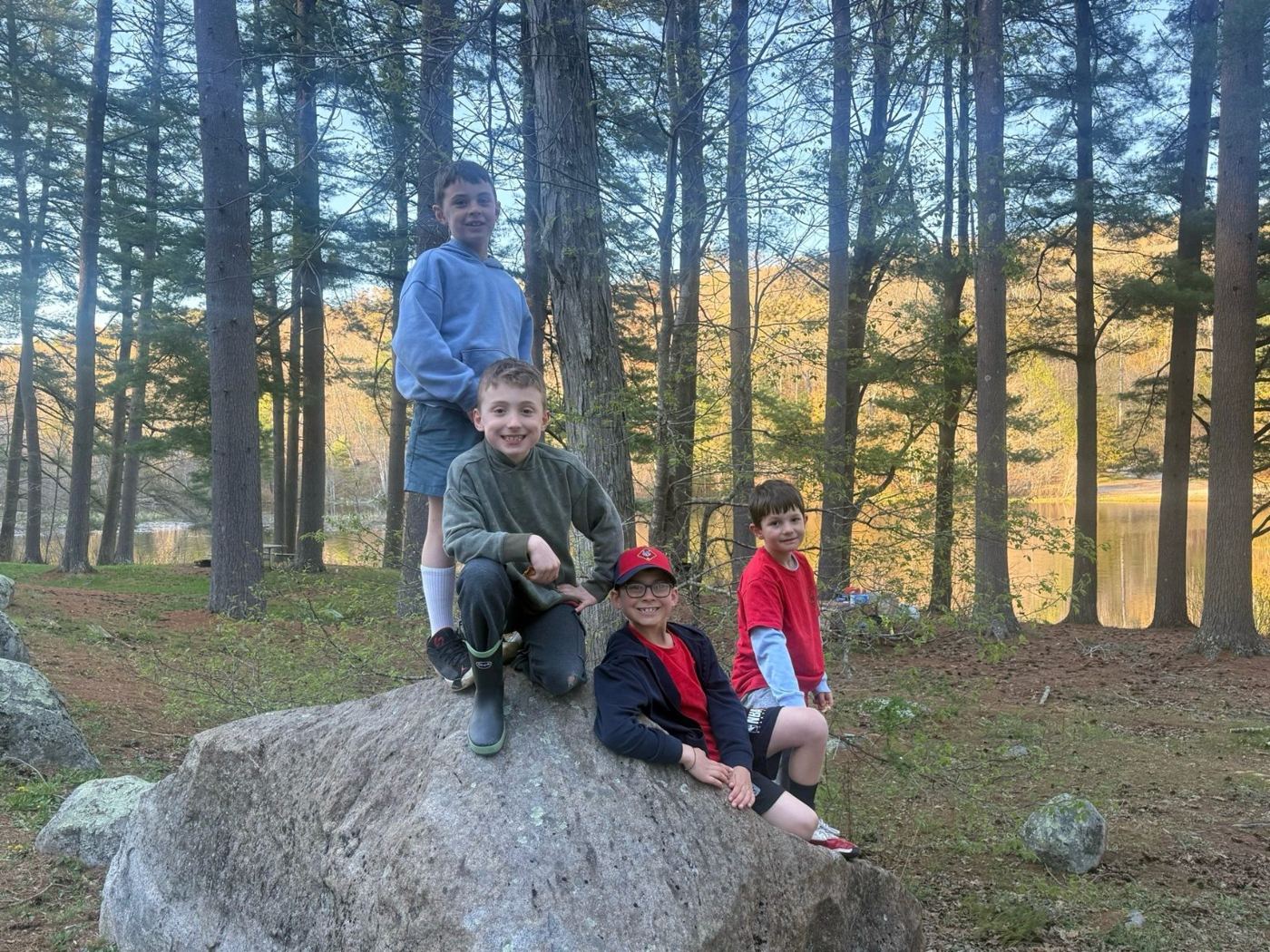 Wolf Scouts sitting on a big rock by the water