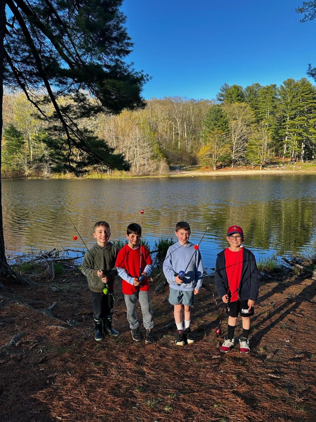 Four Wolf Scouts with fishing rods by a pond